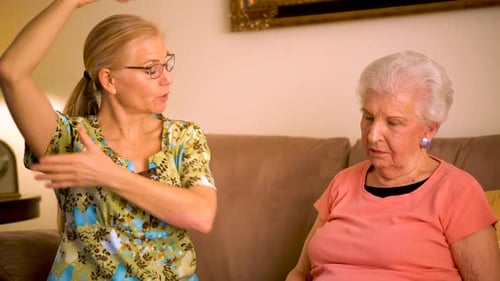 Caregiver Demonstrates Arm Exercises for Senior Woman