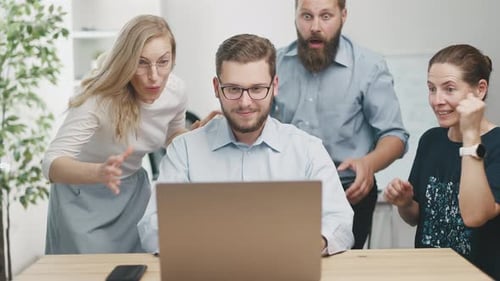 Team Celebrates Business Success at Laptop in Office