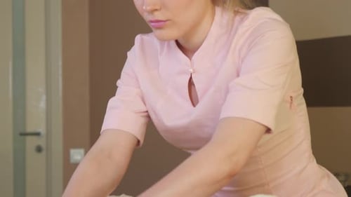 Blonde Masseuse Rubbing Oil on Subject's Torso