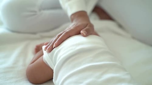 Madre acariciando al bebé acostado en la cama
