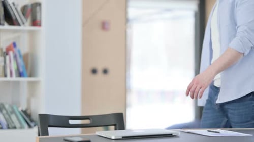 Man Opens Laptop and Begins Working at Desk