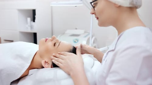 Professional Beautician Making Medical Rejuvenation and Relaxing Spa Massage to Young Female