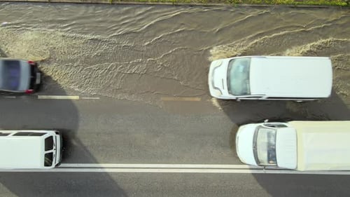 Aerial View of City Traffic with Cars Driving on Flooded Street After Heavy Rain