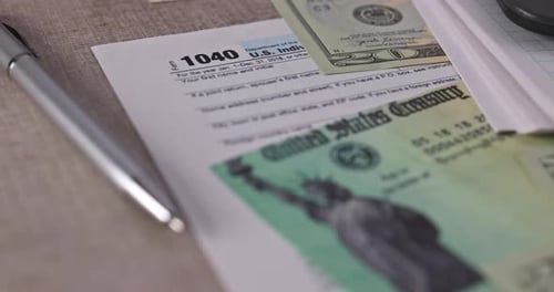 Stimulus Economic Tax Return Check and USA Currency Hundred US Dollar Bills 1040 U