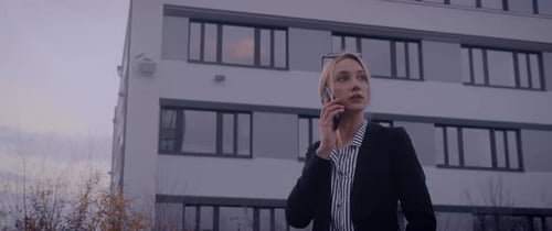 Professional Woman Talking on Smartphone Outside Office Building