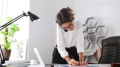 Beautiful Businesswoman Speaking on Phone Writing in Office Slow Motion