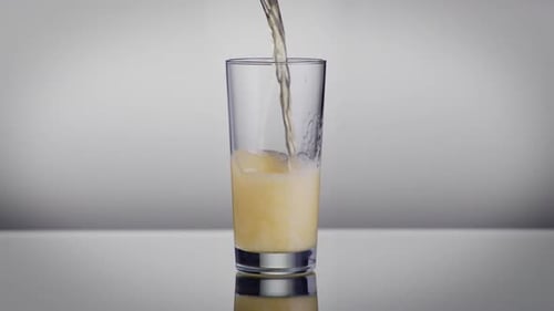 Refreshing Golden Beverage Being Poured in Glass