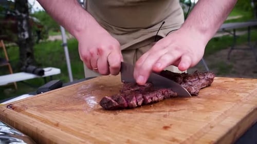 Man Slicing Delicious Steak on Cutting Board