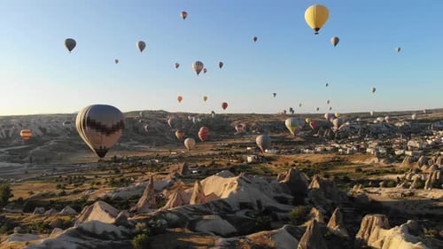 Globos aerostáticos aéreos sobrevolando hoodoos y chimeneas de hadas en el valle de Goreme Capadocia, Turquía