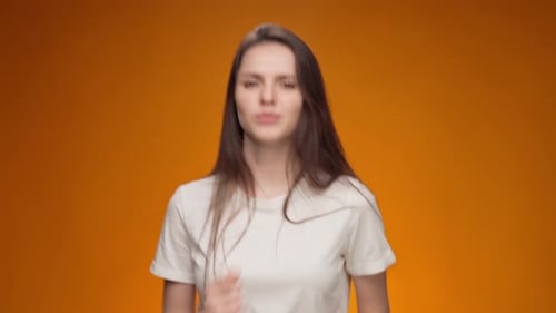 Woman Dancing and Smiling on Orange Background