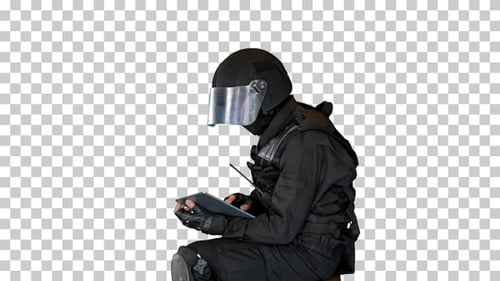 SWAT team officer sitting and using digital tablet, Alpha Channel