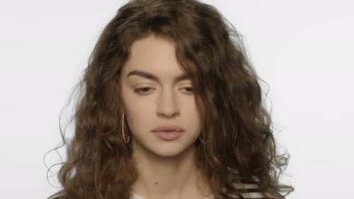 Portrait of Upset Girl Touching Head with Hand in Studio