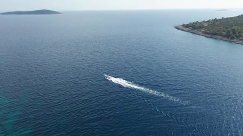 Luftdrohne über kleinem Schnellboot, das in Kroatien an der Adria rauscht