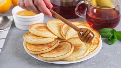 Pancakes Being Drizzled With Honey Close Up