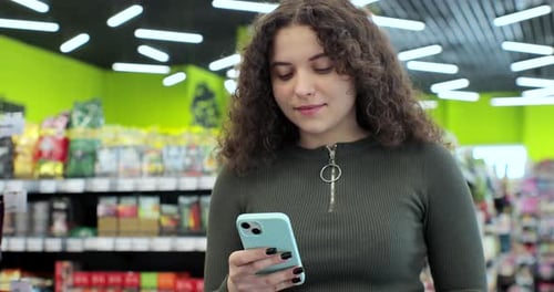 Close Up Young Woman Use Smartphone in Supermarket