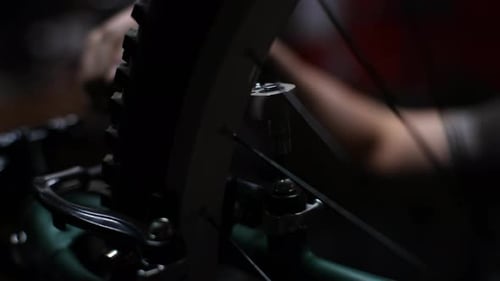 Mechanic Adjusting Bicycle with Wrench in Workshop