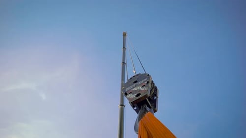 In the Frame Is a Huge Crane Hook. Construction Site, Crane on Huge Belts, Pulls the Load.