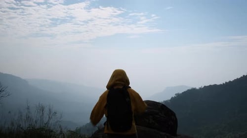Successful woman hiker open arms on top of a mountain.
