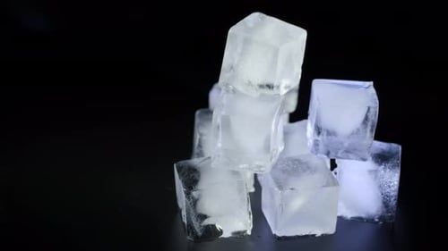 Stack of Ice Cubes Illuminated on Black Background