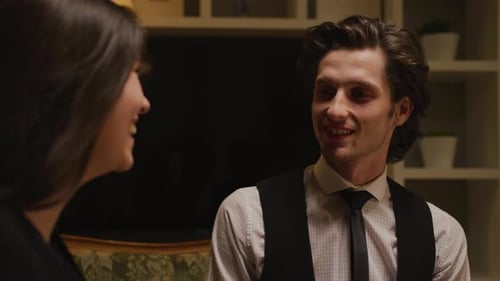 Man and Woman Talking Indoors in Warm Lighting