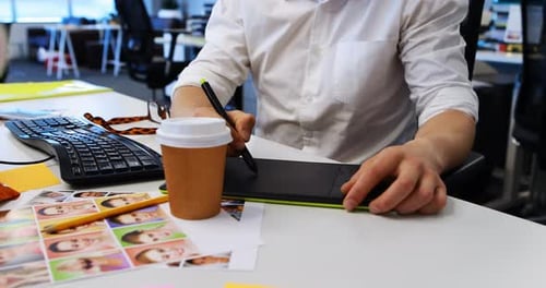 Male graphic designer working on graphic tablet at desk