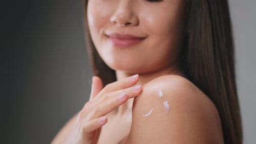 Woman Applying Moisturizer on Shoulder and Neck