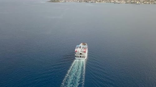 Aerial view following ferry boat with cars in the mediterranean sea, Greece.