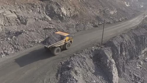Massive Hauler Truck Driving Through Rocky Quarry