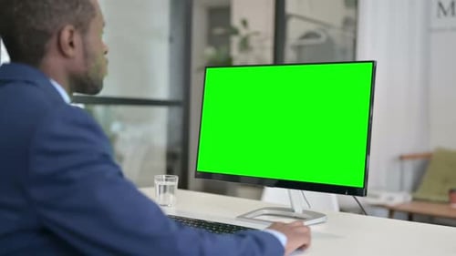 African Businessman Using Desktop with Green Chroma Key Screen