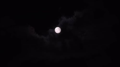 Bright Full Moon Behind Drifting Dark Clouds at Night