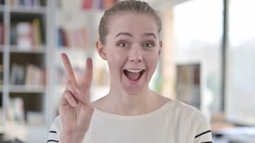 Cheerful Woman Makes Peace Sign Gesture