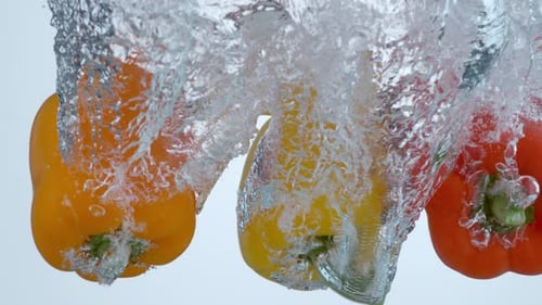 Colorful Bell Peppers Falling Into Water