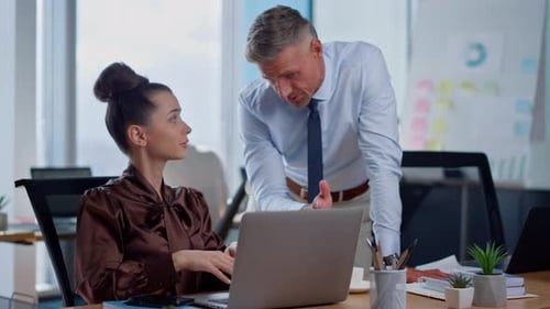 Business Colleagues Collaborate at Desk with Laptop