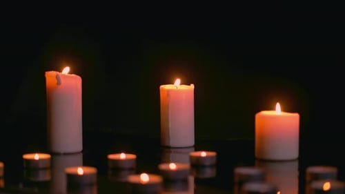 Burning Candles Glowing in the Darkness