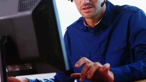 Männliche Führungskraft mit Headset arbeitet am Computer