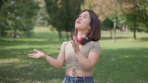 Bonne forme petite femme jouant avec ballon de foot regardant la caméra souriante debout dans Sunny Park