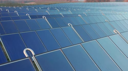 Drohnenschuss von blauen Sonnenkollektoren in einer Reihe im Feld