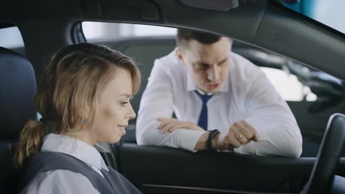 Woman Buying Car from Salesman at Dealership
