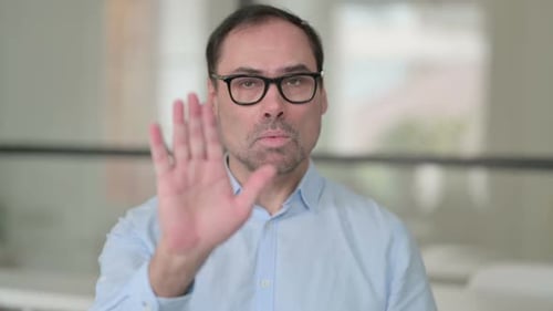 Middle Aged Man Showing Stop Sign By Hand