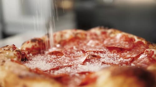 Pizza Getting Topped with Cheese in Restaurant