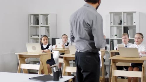 Schwarzer Lehrer gibt Unterricht für Schüler mit Laptops