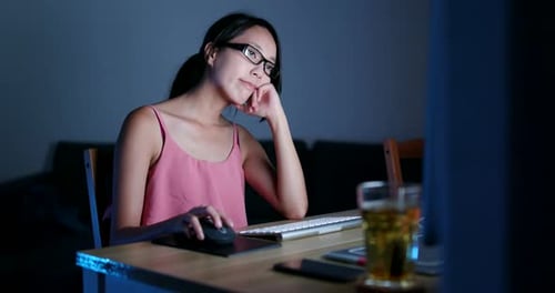 Asian woman working on computer at night