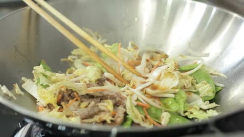 Pouring Oil Over Vegetables in Wok
