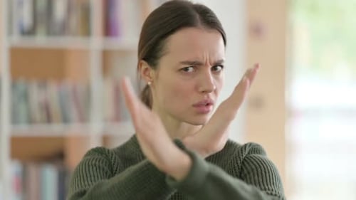 Young Woman Makes Stop Gesture, Sign of Disagreement