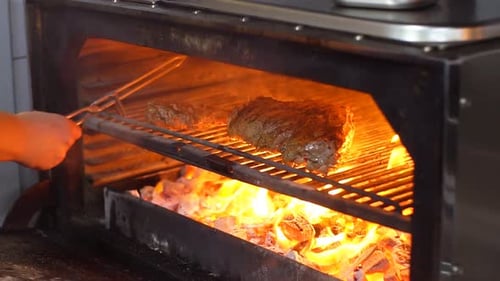 Chef Prepares Beef Steak Slow Motion. Cooking Process on Barbecue Restaurant Kitchen.