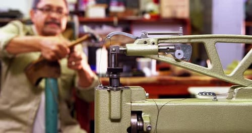Shoemaker Hammering Leather Boot in Workshop