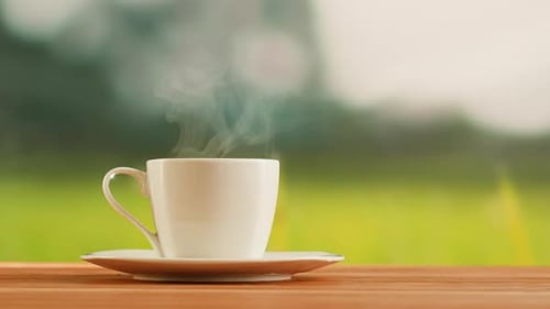 Heißer Kaffee in weißer Tasse auf einem Holztisch