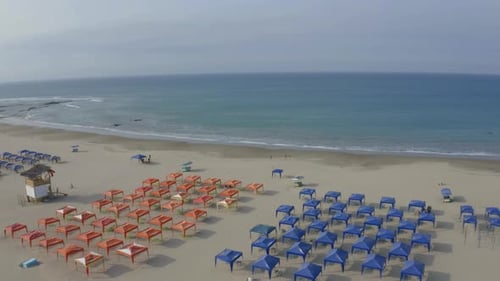 Aerial view, circling around two groups of beach tents in blue and red