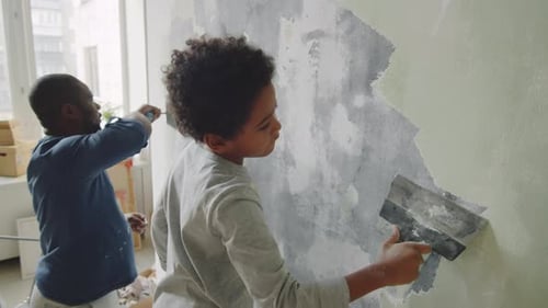 Boy and Man Working on Wall