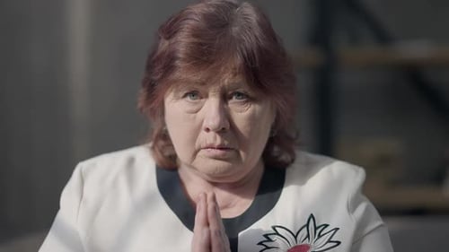 Woman in Blazer with Hands Clasped in Prayer